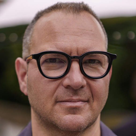 Cory Doctorow facing the camera, on a blurry background
