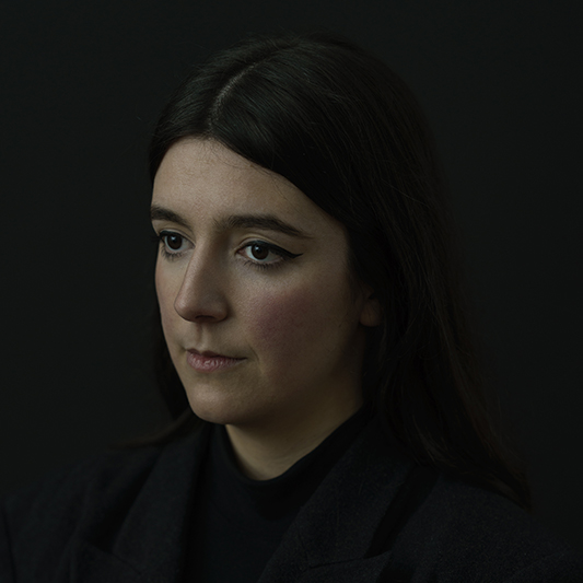 Laura Carreira photographed in the dark suit against a dark background