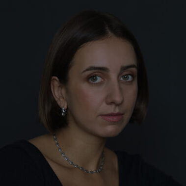 Natalia sitting on the chair in the studio. Low light. She's very peaceful.