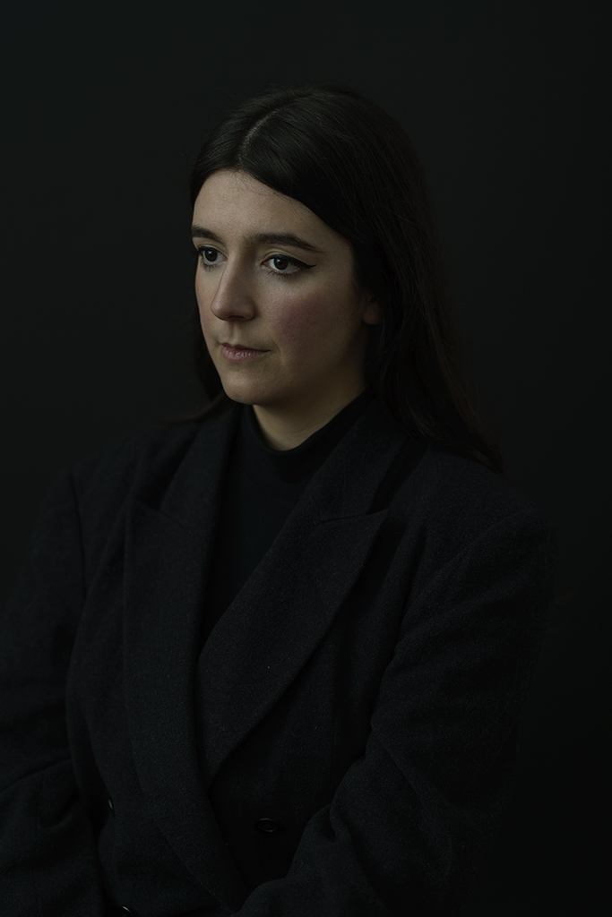 Laura Carreira photographed in the dark suit against a dark background