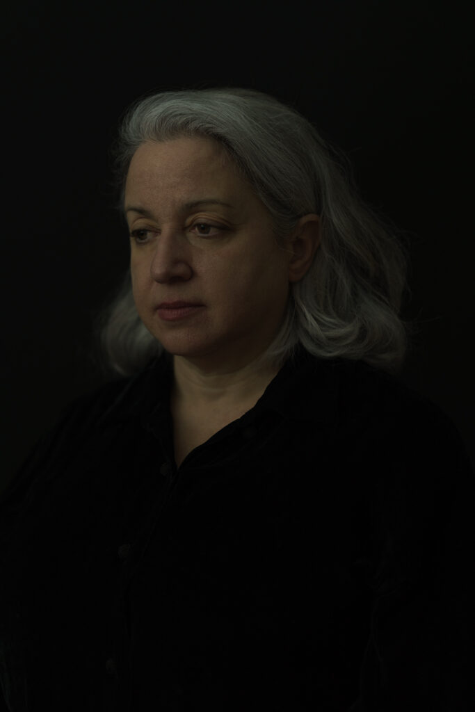 A painterly photograph of Ruth, middle-aged woman, looking peacefully off-camera.